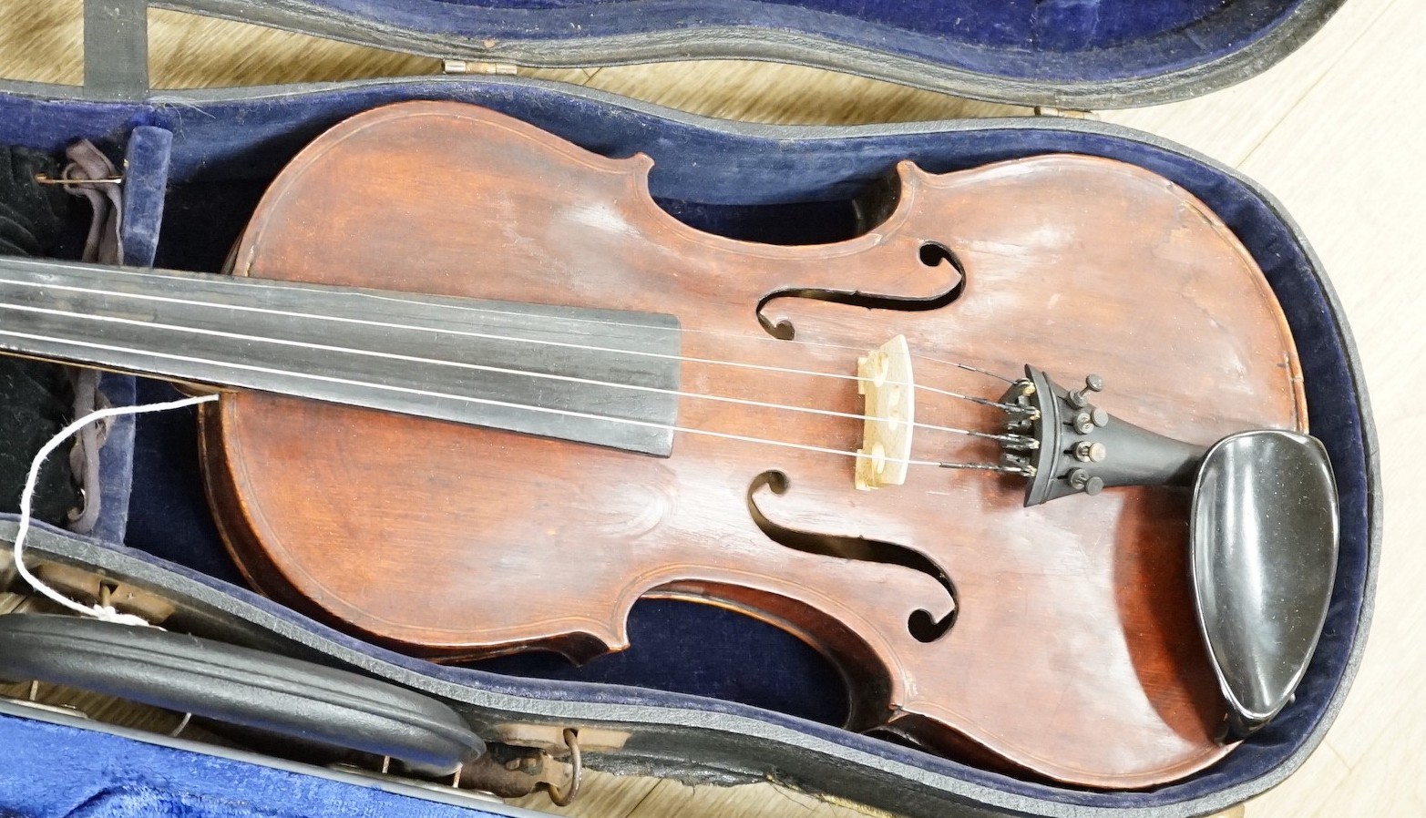 A violin, with carved lion head scroll and two bows in one case